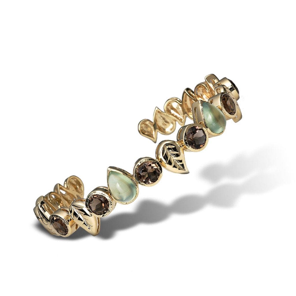 A leaf and gemstone cuff bracelet with an eye pleasing alternating design in fine gold