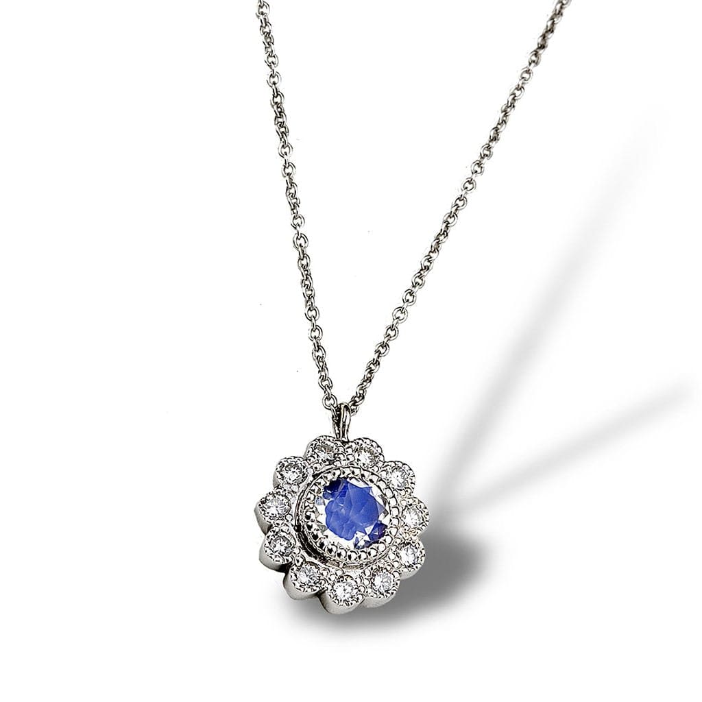 A floral motif daisy pendant in antiquing with diamonds and moonstone