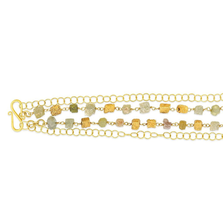 A layered necklace with a circular chain and a textured enriched 18K yellow fine gold squares with square rough diamonds