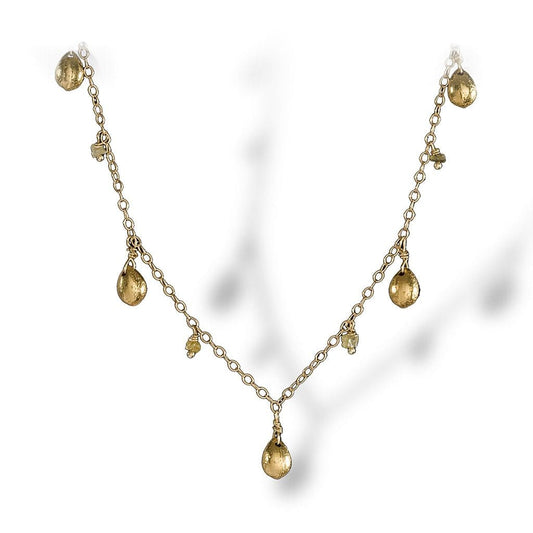 A dainty necklace of textured enriched 18K yellow fine gold teardrops with rough diamonds 