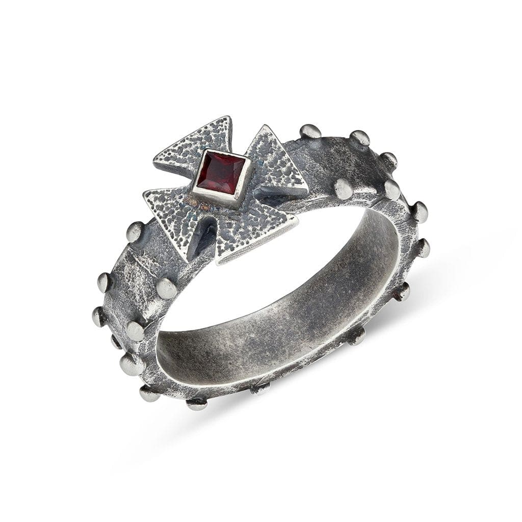 A Maltese cross ring design with multi-textured finishes and a ruby stone center